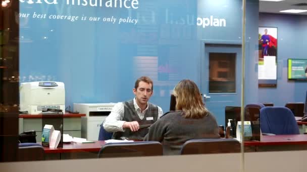 Homme calculant le montant de l'assurance automobile pour le client à l'intérieur de la compagnie d'assurance — Video