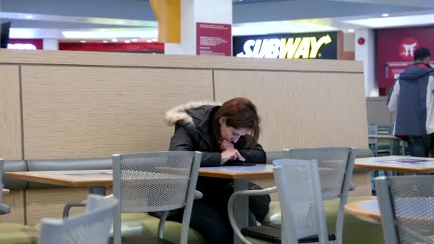 Woman reading message on mobile phone  in modern mall food court cafeteria — Stock Video