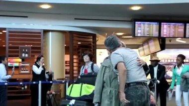 Kadın kocası Vancouver Bc Kanada Uluslararası varış lobisinde, öpüşme.