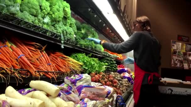Рабочий наливает воду на овощи для продажи в продуктовом магазине в отделе — стоковое видео