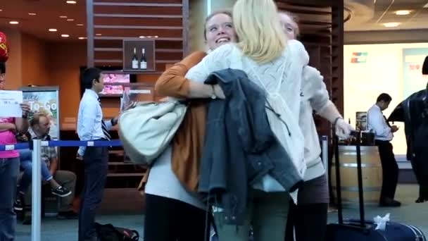Vrouw haar vriend knuffelen bij internationale aankomst lobby in Vancouver Bc Canada. — Stockvideo