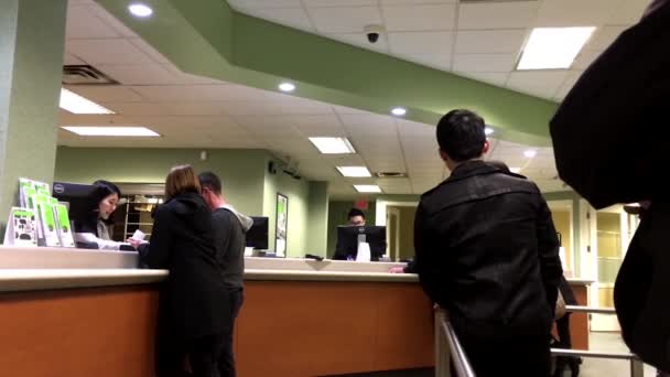 Personas en el mostrador de servicio hablando con el cajero dentro de TD Bank — Vídeo de stock