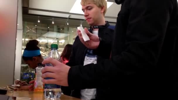 One side of people playing new iphone inside Apple store — Stock Video