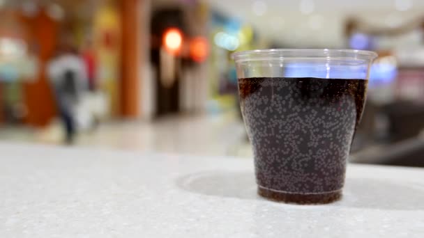 A cup of coca cola on table inside shopping mall — Stock Video