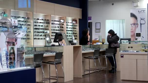 Optician fêmea encontrar um óculos adequados para o cliente — Vídeo de Stock