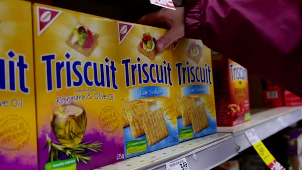 Donna che seleziona Triscuit biscotto a basso contenuto di sodio nel negozio di alimentari — Video Stock
