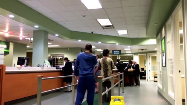 People at service counter talking to the teller inside TD Bank — Stock Video