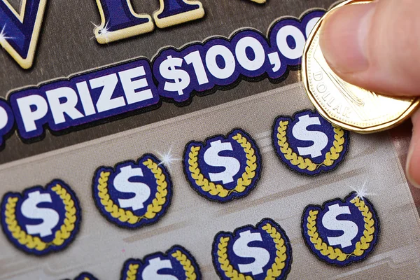 Женщина царапает лотерейный билет — стоковое фото