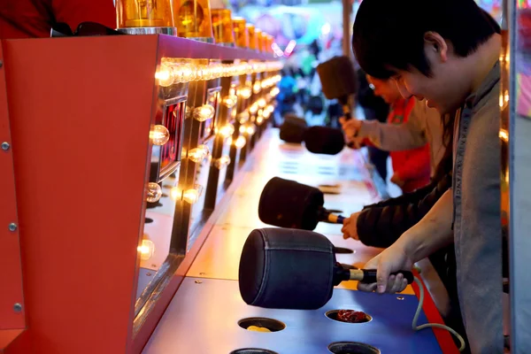 People playing whack game at carnival — Stock Photo, Image