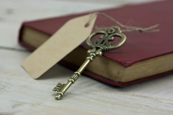 Oude sleutels en boek op een rustieke achtergrond — Stockfoto