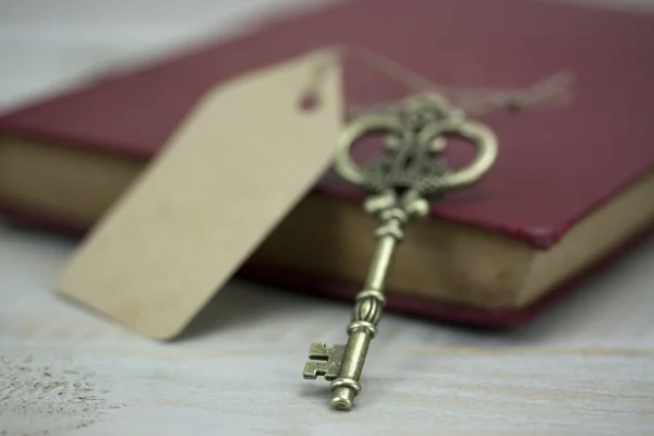 Oude sleutels en boek op een rustieke achtergrond — Stockfoto