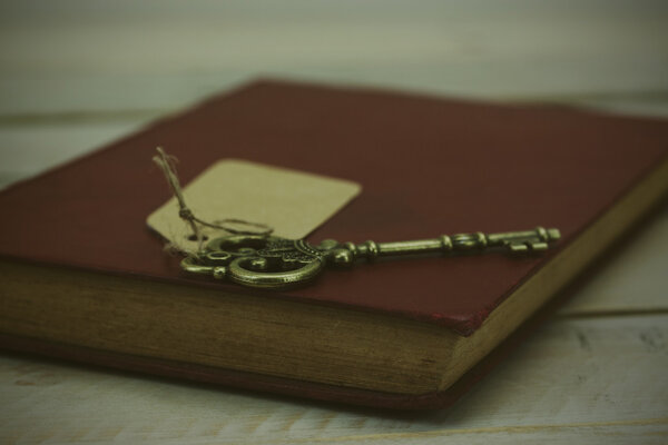 Old keys and book on a rustic background