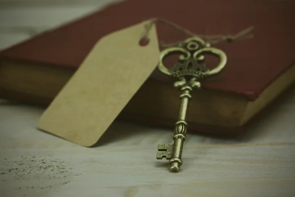 Old keys and book on a rustic background — Stock Photo, Image