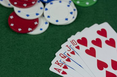 Poker fişleri ve yeşil bir masada kartları