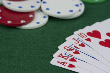 Poker fişleri ve yeşil bir masada kartları