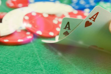 Poker fişleri ve yeşil bir masada kartları