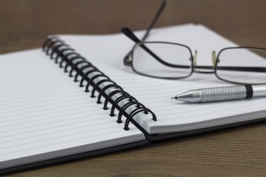 Ahşap arka plan üzerinde siyah sarmal ilişkili not defteri