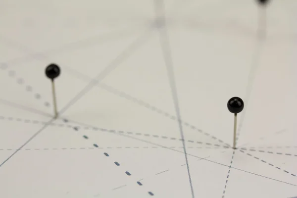 Zwarte pinnen in papier door lijnen met elkaar verbonden — Stockfoto