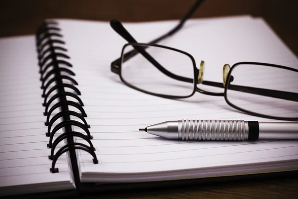 Zwarte spiraal gebonden notebook op houten achtergrond — Stockfoto