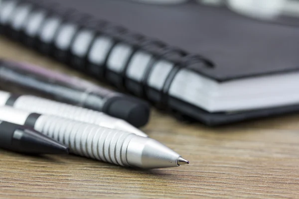 Zwarte spiraal gebonden notebook op houten achtergrond — Stockfoto