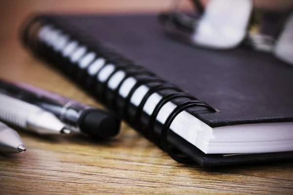 Zwarte spiraal gebonden notebook op houten achtergrond — Stockfoto