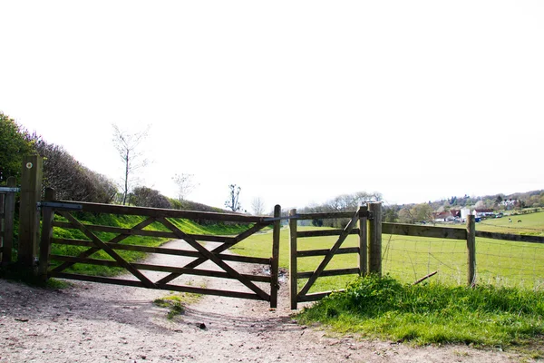 Puerta de madera a través de un camino en el campo —  Fotos de Stock