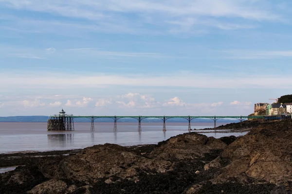 View over rocks at Clevedon sea front, including pier in backgro — Stock Photo, Image