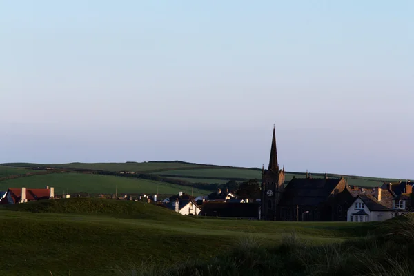 Vista através de um campo de golfe para a igreja atrás — Fotografia de Stock