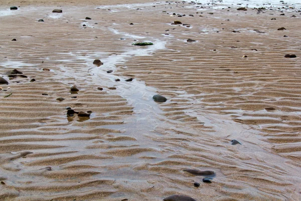 ビーチの砂の上を実行している水 — ストック写真
