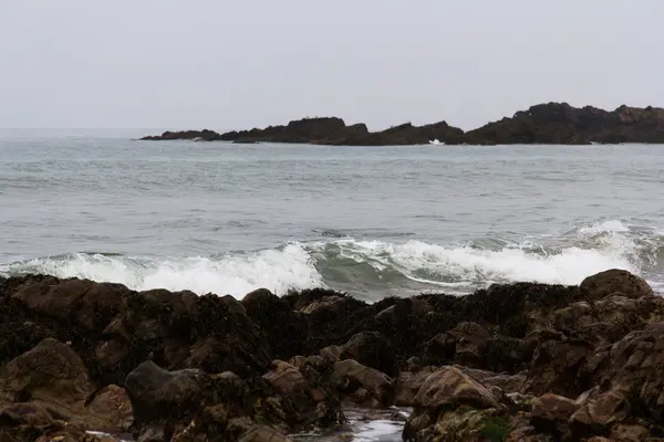 Olas sobre las rocas en la playa — Foto de Stock