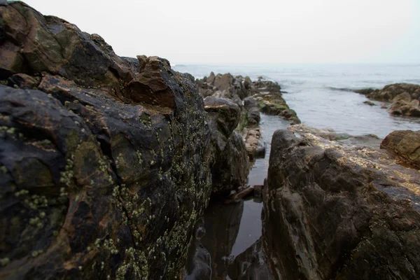 Golven over de rotsen op het strand — Stockfoto