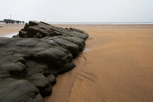 Nat zand en stenen op het strand — Stockfoto