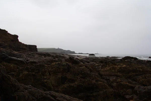 Hullámok át a sziklák a tengerparton — Stock Fotó