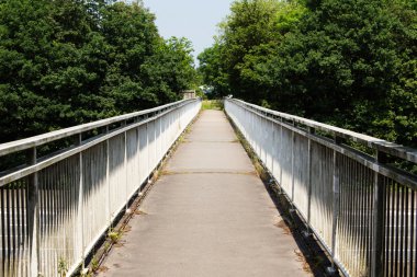 Uzun bir yaya köprüsü ile iki tarafında parmaklıklar boyunca görüntülemek