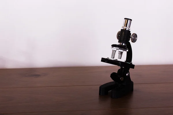 Microscoop op een tafel voor wetenschap achtergrond — Stockfoto