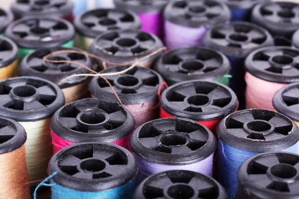 Scattered cotton reels on a wooden surface — Stock Photo, Image