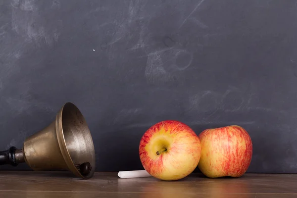 Ouderwetse bell en apple tegen een schoolbord — Stockfoto