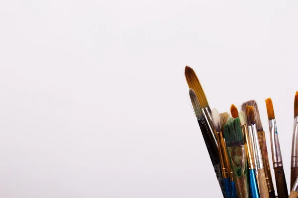 Verf penselen in een pot tegen een witte achtergrond — Stockfoto