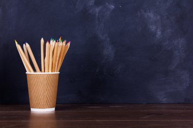 Yıpranmış siyah arka plan üzerinde renkli kalemler