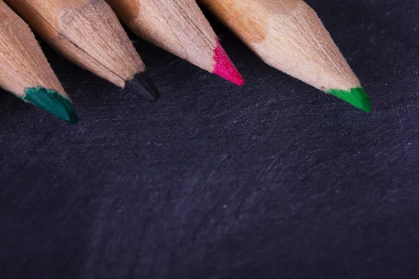Crayons de couleur sur fond noir usé — Photo