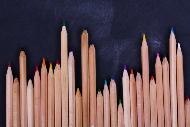 Yıpranmış siyah arka plan üzerinde renkli kalemler