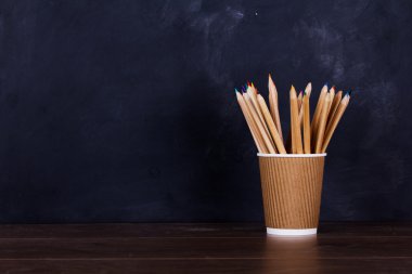 Yıpranmış siyah arka plan üzerinde renkli kalemler