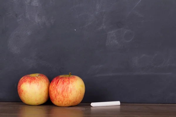 Apple op een houten oppervlak tegen een schoolbord — Stockfoto