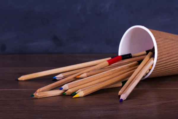 Kleurpotloden op een versleten zwarte achtergrond — Stockfoto