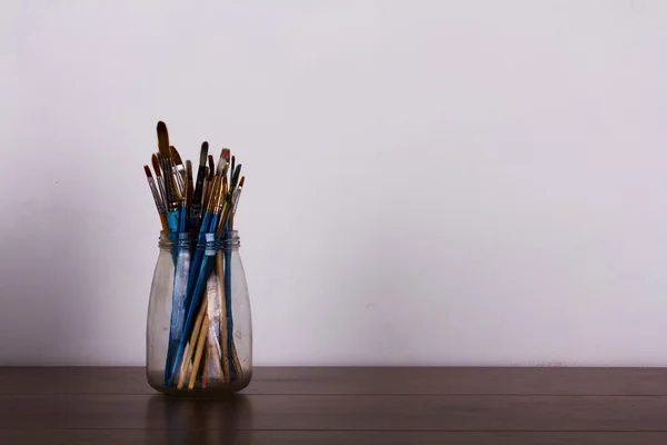 Verf penselen in een pot tegen een witte achtergrond — Stockfoto