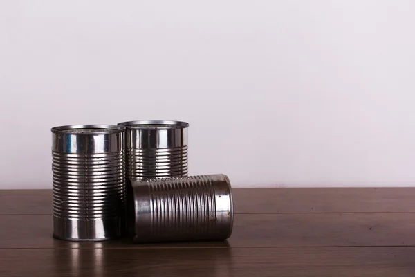 Battered tin cans on a wooden background — Stock Photo, Image