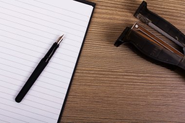 Görüntü bir defter ve zımba bir ahşap yüzeye yat