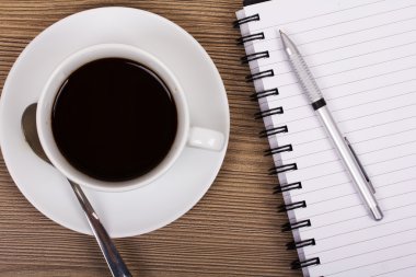 Fincan sade kahve ve ahşap yüzey üstünde defter