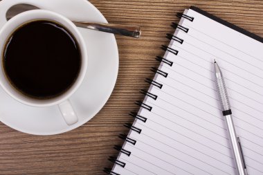 Fincan sade kahve ve ahşap yüzey üstünde defter
