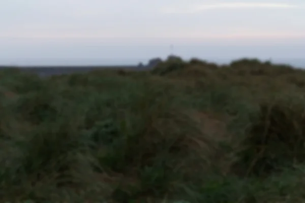 Vista desde las dunas de arena al amanecer Fuera de foco . — Foto de Stock